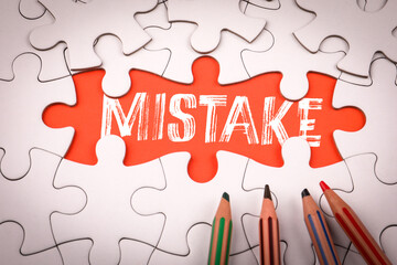 MISTAKE. White puzzle pieces and colored pencils