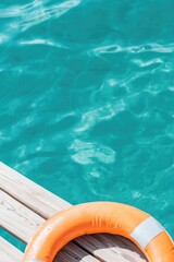 Bright orange lifebuoy rests on wooden dock by shimmering turquo