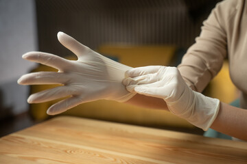A hand is shown carefully putting on a medical glove in preparation for a clinical procedure. The...