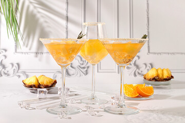 Summer party concept. Tequila, rum and vodka cocktail with pineapple, orange, ice and rosemary...