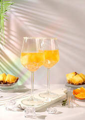 Summer party concept. Tequila, rum and vodka cocktail with pineapple, orange, ice and rosemary slices. Diet drink for body detox and weight loss, advertising for a bar or cafe, menu for a restaurant.