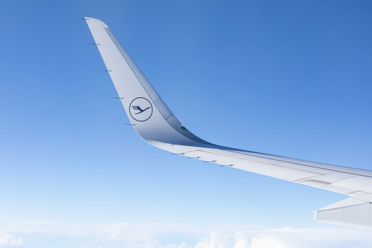 Lufthansa logo on the wing of a plane in flight above the clouds