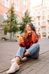 Young woman listening music while walking in the street. Travel, tourism, technology, blogging...