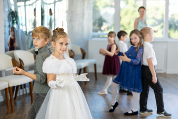 Beautifully dressed little boys and girls dance a couple twist dance