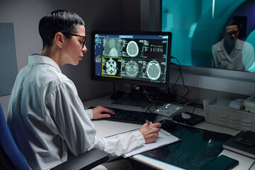 Doctor analyzing detailed brain scans in modern medical laboratory with advanced equipment,...
