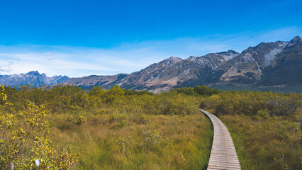 Gorgeous postcard views of glenorchy new zealand mountain peaks blue sky boardwalk bridge path