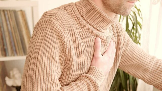 young man experiences experiences sudden chest pain behind sternum, clutching chest, Arterial hypertension, Myocarditis or Arrhythmia, Ischemic heart disease, seeking immediate medical attention