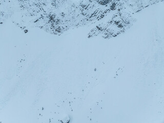 Aerial view of snowy mountain slope. Texture of snow surface from above.