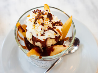 Classic French dessert Poires belle Helene of pear slices simmered in sugar syrup served with vanilla ice cream and chocolate sauce