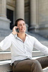 Young entrepreneur laughing while talking on the phone in the city