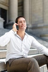 Young entrepreneur laughing while talking on the phone in the city