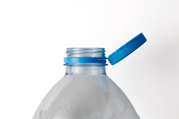 Open plastic bottle with blue cap on white background