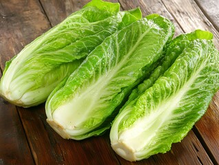 Fresh crisp romaine lettuce heads on rustic wood.