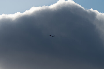 An airplane begins to circle against a backdrop of thick clouds
