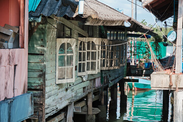 Wooden houses on stilts beside the water in a quaint fishing village during daylight hours