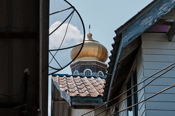 Golden dome rises above rooftops in a tranquil neighborhood showcasing architectural diversity