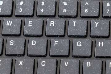 A close-up of a dusty black keyboard