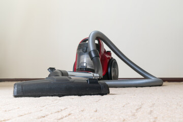 Vacuum cleaner on beige carpet. Cleaning the apartment.