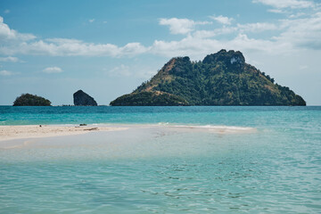 Beautiful tropical beach landscape featuring islands and clear turquoise water under a bright sky