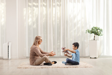Woman sitting on a carpet with a kid