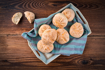 Freshly baked Kaiser rolls offered as top view on a rustic wooden tray