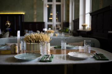 modern table setting in a trendy restaurant. Sofa, armchair, table and dishes on the table