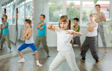Obraz premium Group of boys and girls rehearsing hip hop dance in studio