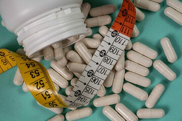 bottle of pills, some of which spilled onto a light blue surface
