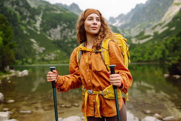 Young woman with backpack hiking in the mountains. Travel, adventure. Concept of an active lifestyle