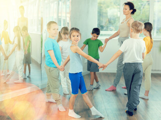 Boys and girls holding hands perform incendiary traditional roundelay folk dance during rehearsal...
