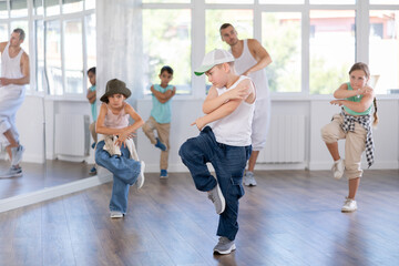 Positive girls and boys training hip hop in dance studio, dance classes for kids