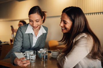 Businesswomen sharing a moment of levity during coffee break