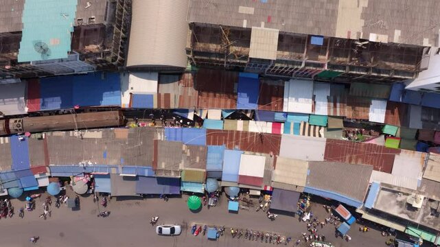 Drone perspective of Maeklong Railway Market with vendors, Thailand. Aerial drone video