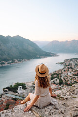 Back view of tourist woman looks at the bay and the city from an observation deck.  Europe travel. Lifestyle, vacation, tourism, nature, active life