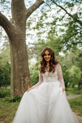 Fototapeta premium young girl bride in a white dress in a spring forest on a wedding day