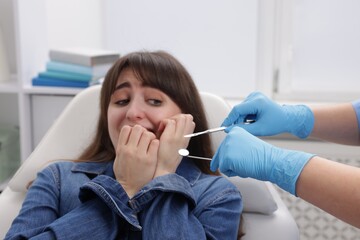 Scared woman having appointment with dentist in clinic