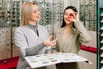 Ophthalmologist explains each type of lenses. Eye and health care. Consulting female client about...