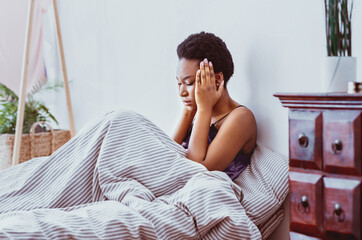 Bad thoughts and dreams. African american girl wakes up at night from headache and suffers from...