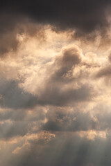 large white thunderclouds with bright rays of sunlight breaking through them