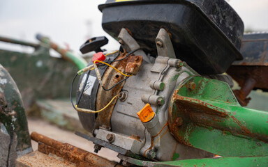 Rusty boat motor with green hull and worn components. Detailed view of old boat engine witg exposed wires and weathered parts. Signs of wear and corrosion. Aging and mechanical decay concept