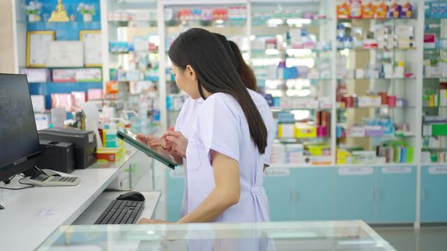 Medical pharmacy clinic, pharmaceutical and healthcare service. Two female pharmacist colleagues working checks stock and manage order of medicine, drugs and medical product on computer at drug store.