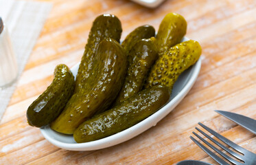 Pile of pickled cucumbers served on table and ready to eat.