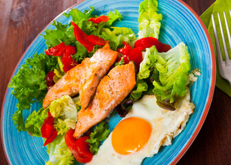 Healthy light breakfast with tender trout fillet, omlette, vegetables and lettuce