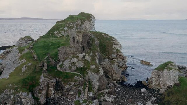 Kinbane Castle in Northern Ireland - A stunning and breathtaking view of a wild, rugged shore showcasing ancient ruins alongside beautiful ocean waves