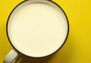 Fototapeta premium Milk in White Mug on Yellow Background