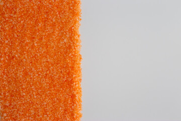 Bright orange sea salt placed on clean surface with copy space