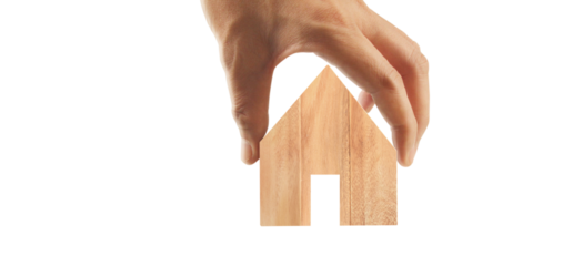 Hand grasping wooden house model home design inspiration minimalist environment indoor setting creative concept for real estate