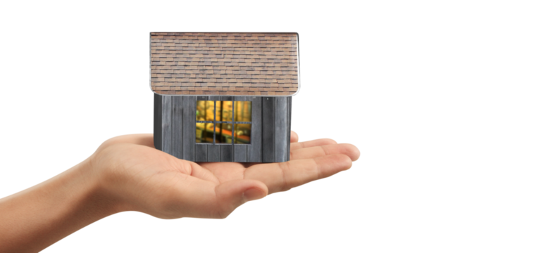 Hand holding miniature house model indoor setting conceptual image modern environment focused viewpoint real estate dreams