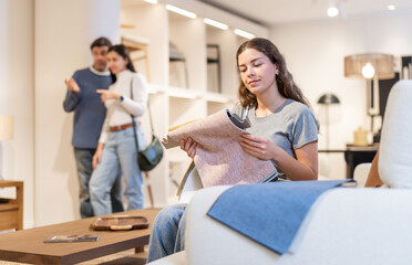 Obraz premium Portrait of woman choosing upholstery fabric in the furniture salon