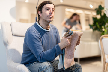 Man in furniture store chooses upholstery for upholstered furniture for his home